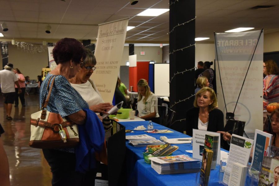 Members sitting at the Muskingum Behavioral Health table talk to visitors that browsed through resources at the Understanding Addiction event at Secrest Auditorium Tuesday.