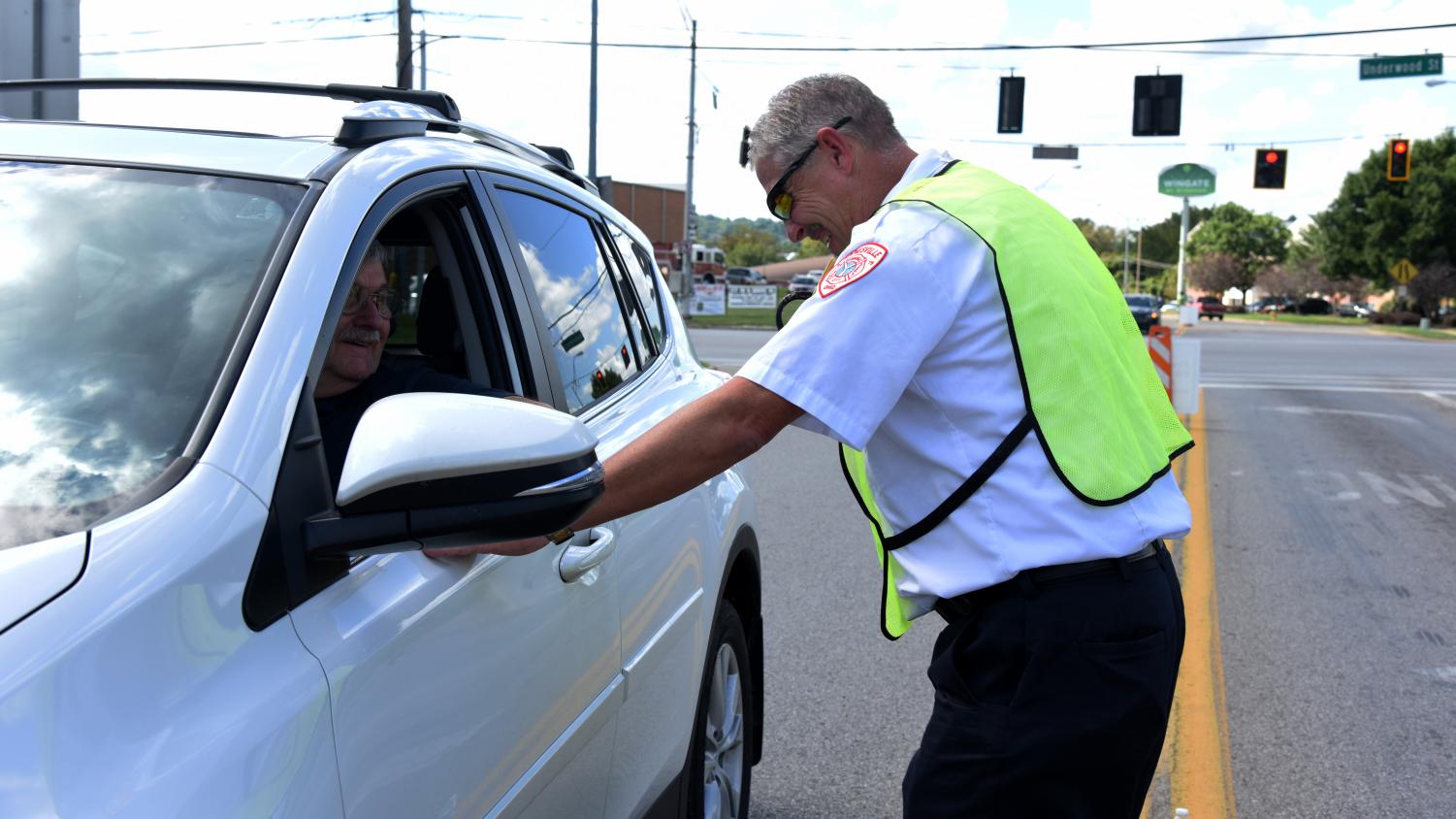 Interim Fire Chief Doug Hobson jokes with a community member after he donates to the