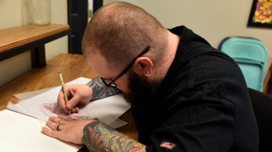 Travis Kilpatrick, the owner of Downtown Tattoo, traces the outline for an upcoming tattoo. Kilpatrick and his other tattoo artists are donating 100 percent of the profits from tattooing on Sept. 29 to the Animal Shelter Society.