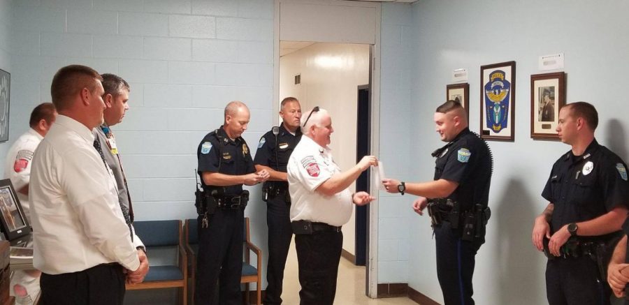 Patrolman Jeremy Downing is presented with The Life Saving Award surrounded by other ZPD officers. Photo provided by the Zanesville Police Department.