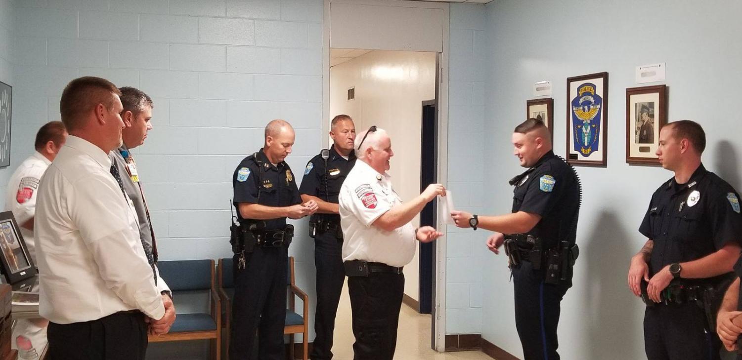 Patrolman Jeremy Downing is presented with The Life Saving Award surrounded by other ZPD officers. Photo provided by the Zanesville Police Department.