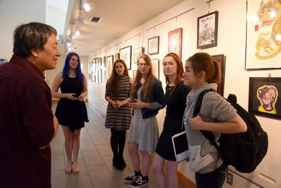 Professor Yan Sun asks Daphne Woodmansee of John Glenn High School about her background in art while talking to a group of artists from John Glenn.