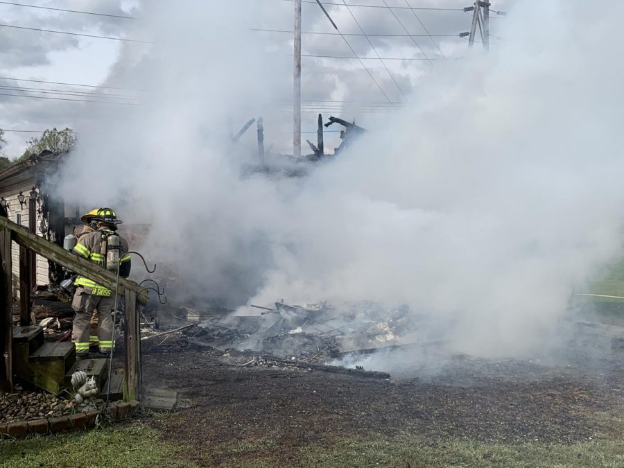 Firefighters work to extinguish the flames from a detached garage fire at the intersection of Elm Street and 3rd Street.