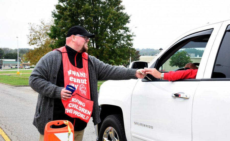 Kiwanis member, Sean Fennell, exchanges a small bag of peanuts with a driver for a donation to the organization.