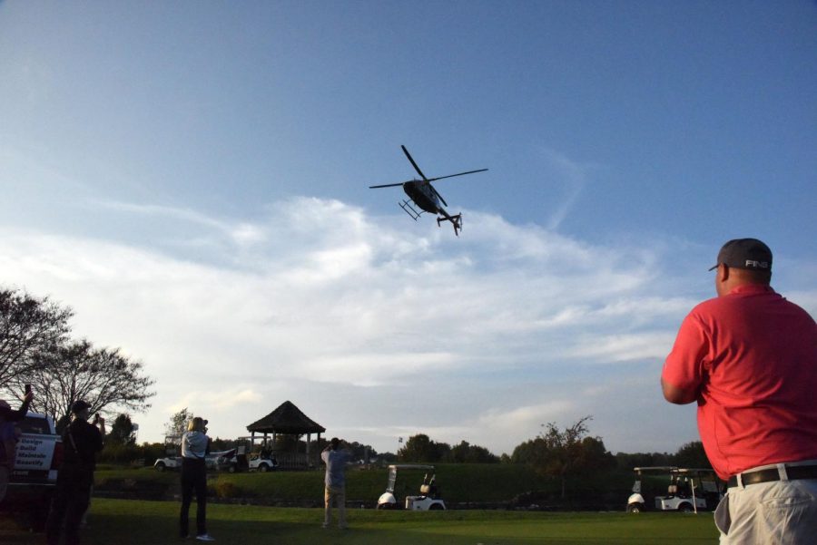 A helicopter flies over a green space at EagleSticks to drop golf balls for the annual ForeverDads golf outing.