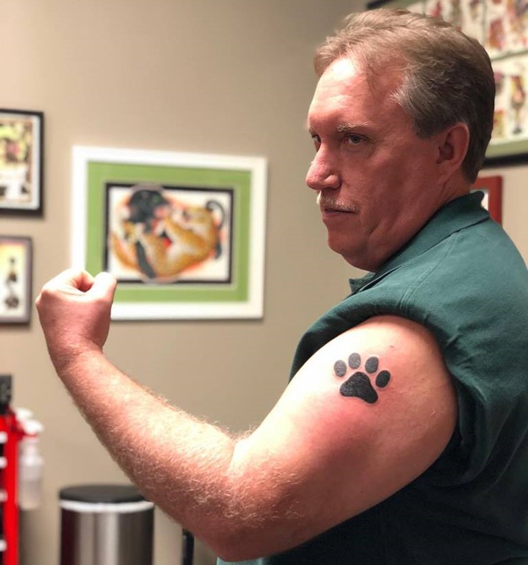 The Animal Shelter Society Assistant Director, Russ Denny, posing with his new tattoo. Photo provided by Denny via the Animal Shelter Societys Facebook Page.