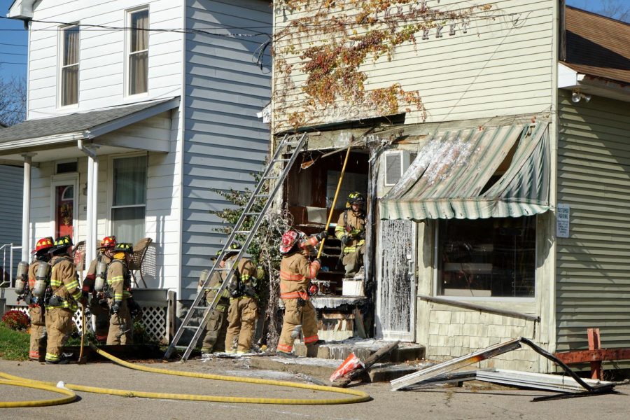 Firefighters breakdown the damaged front wall of the former Kimbles Meat Market Wednesday afternoon.