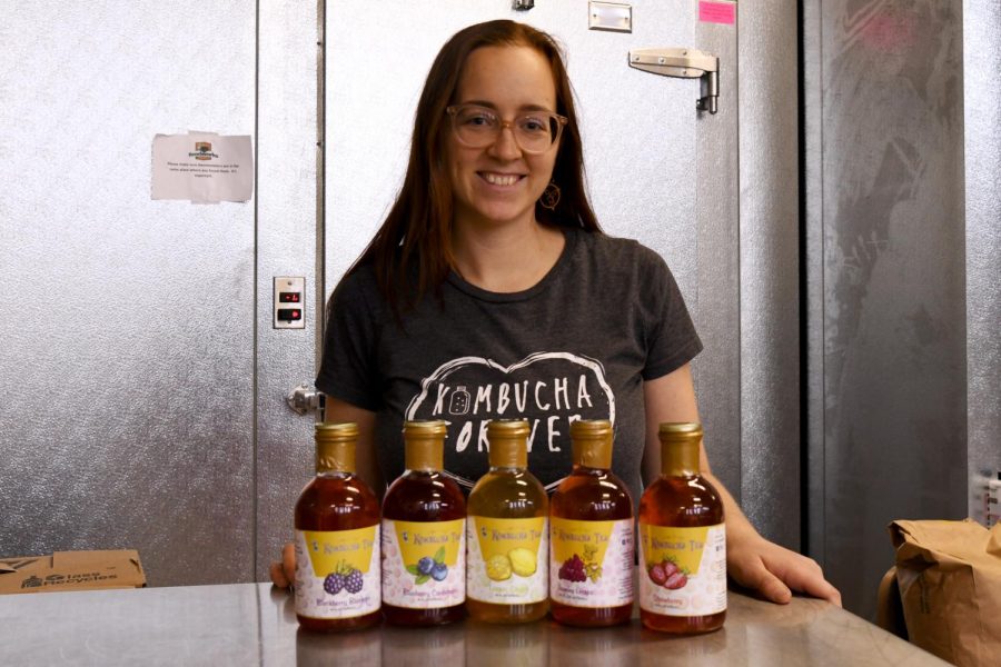 Junita Lapp poses in front of her five regular flavors of kombucha tea at the Foodworks Alliance kitchen on Dec. 20.