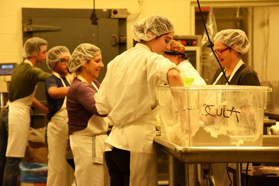 A crew of six, including Cecilia Ciarlo (middle left) pack the baking mix bags in the Foodworks Alliance kitchen on Nov. 30.