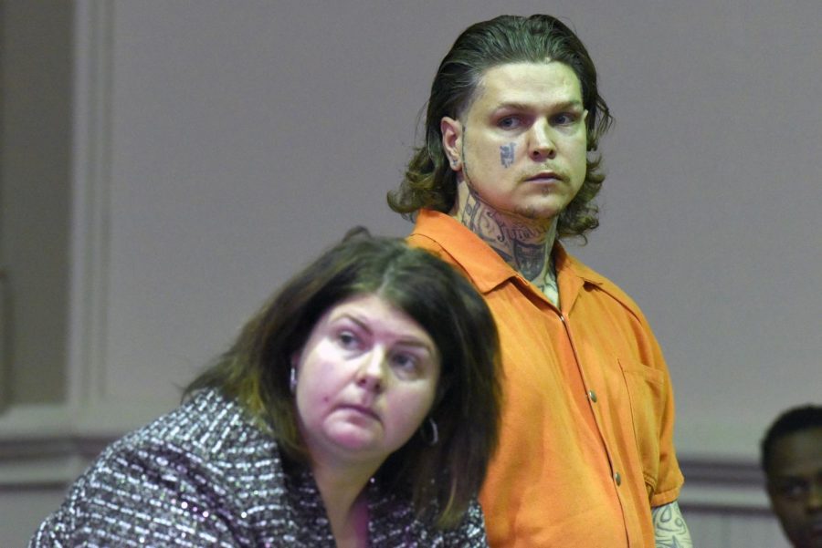 John Hampton (back) stands in court with his defense attorney Kendra Kinney (front).