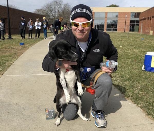 Dr. Lori Wahl’s husband poses with one of their three dogs after finishing second in his category during the 2018 Dog N’ Jog. | Photo provided by Dr. Lori Wahl.