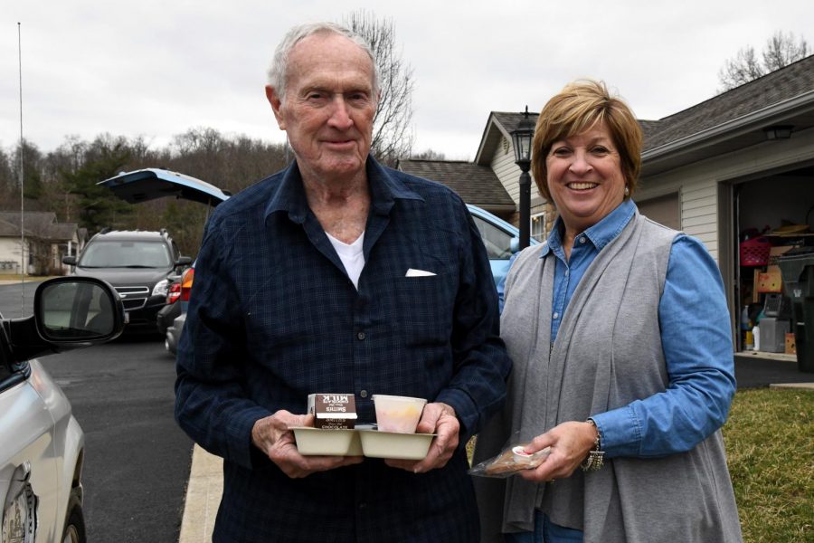 Muskingum County Commissioner Cindy Cameron (right) gives senior citizen William Hill (left) his daily meal during Fridays March for Meals initiative.