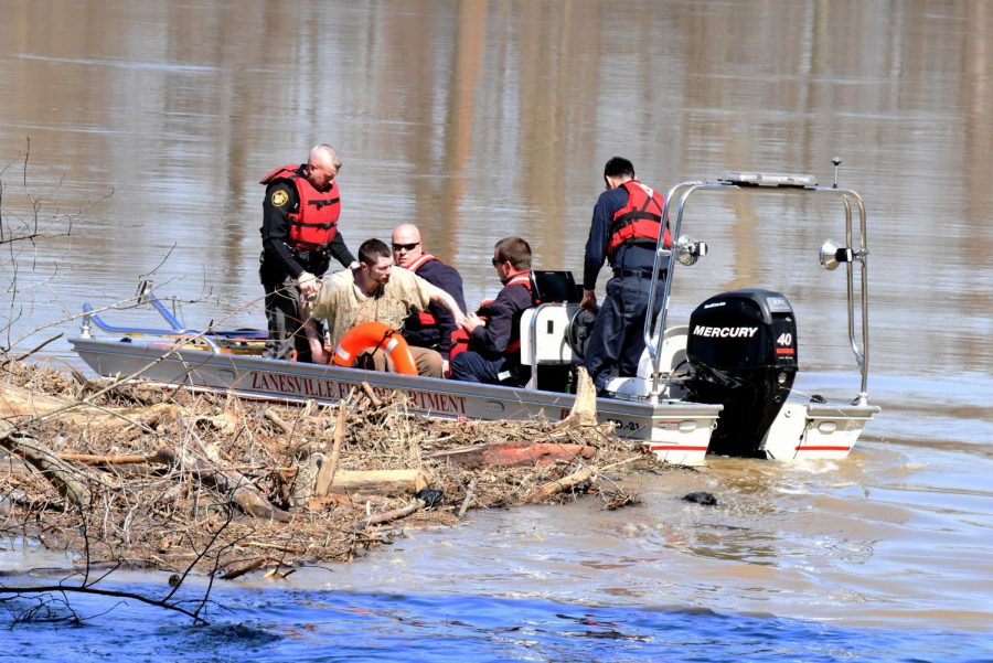 The inmate begins to take off his wet shirt after authorities pulled him from the river.