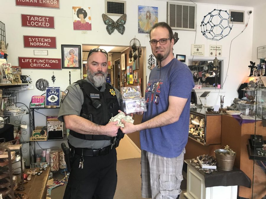 Head Dog Warden Bryan Catlin (left) stands alongside owner of Geminis Eclectic Emporium Jimi Campsey to accept a the adoption centers donation.