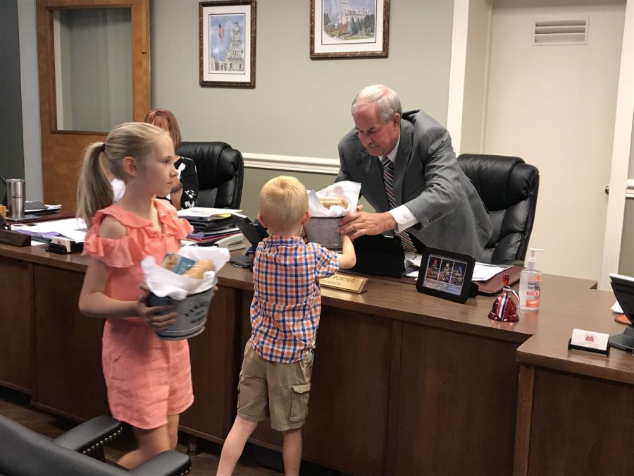 Rachel and J Hodges two children hand out tins of dairy-themed goodies to the Muskingum County Commissioners Monday afternoon.
