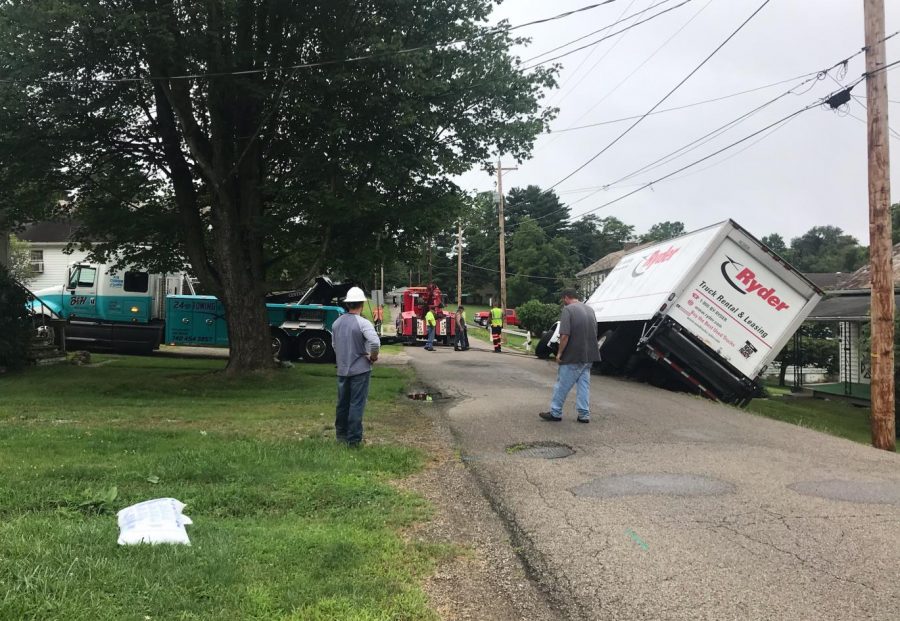 Box truck overturns into front yard