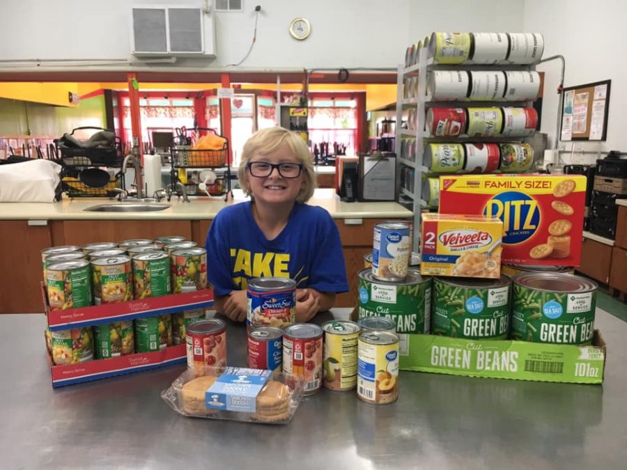 James McCandlish smiles next to the food he collected for Christ's Table on his ninth birthday.