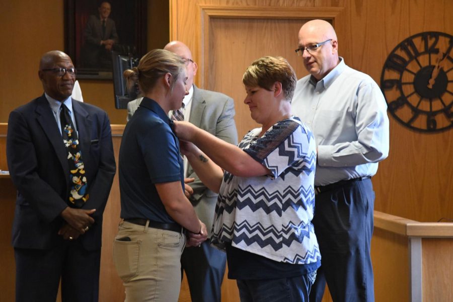 Haley McLean stands among Public Safety Director Keane Toney, Mayor Jeff Tilton and Police Chief Tony Coury as McLeans mother placed her pin on her shirt during her swearing in ceremony.